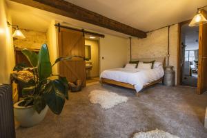 a bedroom with a bed and a potted plant at The Dairy in Lifton
