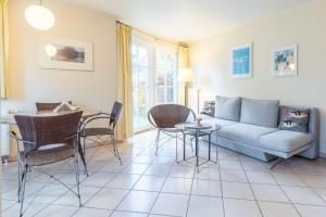 a living room with a couch and a table and chairs at Fewo Seelenanker in Thiessow