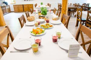 a long table with plates of food on it at Ułańska Zagroda in Człopa