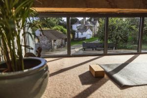 a window with a potted plant and a bench in a room at The Dairy in Lifton