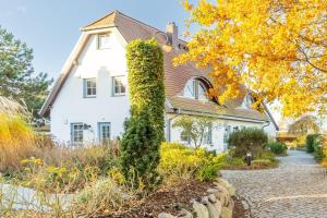 a white house with a hedge in front of it at Fewo Seelenanker in Thiessow