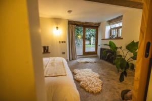 a bedroom with a bed and a large window at The Dairy in Lifton