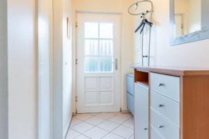 a kitchen with a white door and a tile floor at Fewo Seelenanker in Thiessow