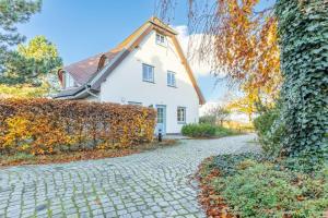 a stone driveway in front of a white house at Fewo Seelenanker in Thiessow +3 photos