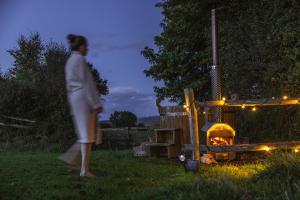 a woman walking in the grass next to a grill at The Dairy in Lifton +5 photos