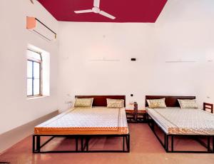two beds in a room with a ceiling at Hotel Goram Garh Resort in Pāli