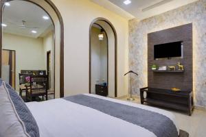 a bedroom with a bed and a flat screen tv at Shyama Inn by Rivlet, Delhi in New Delhi