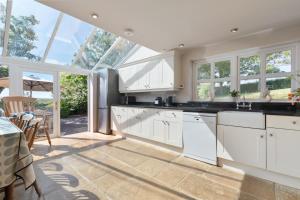 a kitchen with white cabinets and glass windows at 4 Bed in St. Brides oc-h30490 in Saint Brides