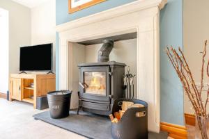a fireplace in a living room with two trash cans at 3 Bed in Gunnerside oc-ds097 in Gunnerside