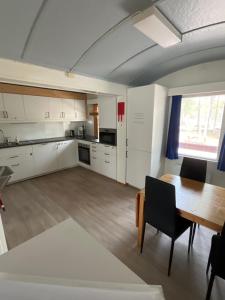 a kitchen with white cabinets and a wooden table at Hendriks Matz-Roan in Åmot