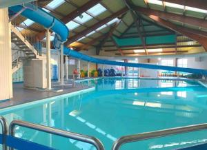 a large swimming pool with blue waters at Ty Mawr Summerbreeze in Kinmel Bay
