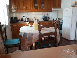 eine Küche mit einem Tisch und einem weißen Kühlschrank in der Unterkunft Georgia's in Ayía Kiriakí