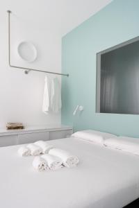 a bedroom with a white bed with towels on it at VIVO Rooms in Civitanova Marche