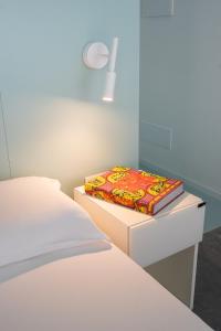 a white room with two beds and a lamp on a drawer at VIVO Rooms in Civitanova Marche +17 photos