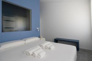 a bedroom with two white beds with towels on them at VIVO Rooms in Civitanova Marche