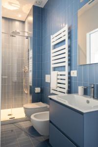 a blue bathroom with a toilet and a sink at VIVO Rooms in Civitanova Marche