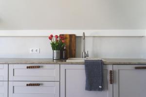 a kitchen with a sink and a vase of flowers at Mia Hotel in Orissaare +35 photos