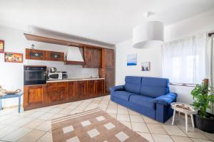 a living room with a blue couch and a kitchen at Camping Italia 90 Two Levels Apartment in Domaso