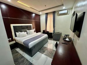a hotel room with a bed and a desk at Chinbell Luxury Hotel & Suites in Lekki