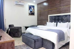 a hotel room with a large bed and a chair at Chinbell Luxury Hotel & Suites in Lekki +26 photos