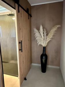 a black vase with feathers sitting next to a door at Ferienwohnung Marina in Wiesmoor