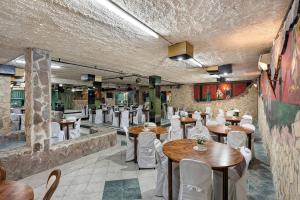 a restaurant with wooden tables and white chairs at B&B H Pompeii Ruins in Pompei
