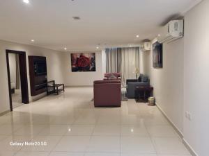a living room with a couch and a chair at Taleen Serviced Apartments Al-Ahsa- تالين الاحساء للشقق المخدومة in Ruqaiqah