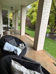 a patio with a couch and a table with a laptop at Woodlands - Vineyard setting in Penwortham
