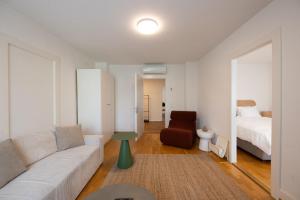 a living room with a couch and a bed at Stadtloft Suites Zürich- Oerlikon in Zurich