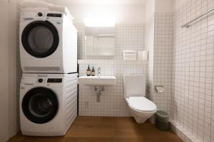 a bathroom with a washing machine and a toilet at Stadtloft Suites Zürich- Oerlikon in Zurich