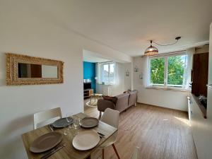 a living room with a table and a dining room at La Boierie - City Appart's in La Flèche +10 photos