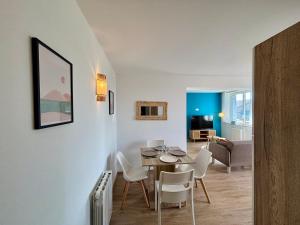 a dining room and living room with a table and chairs at La Boierie - City Appart's in La Flèche