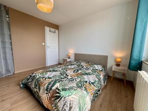 a bedroom with a bed with a colorful bedspread at La Boierie - City Appart's in La Flèche