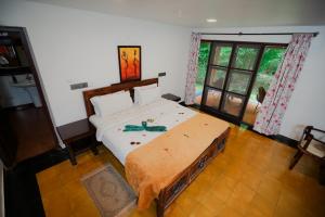 a bedroom with a large bed in a room at Red Earth Kabini in Begūr