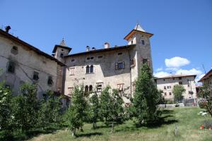 un vecchio edificio con alberi di fronte di Locanda Alpina a Brez