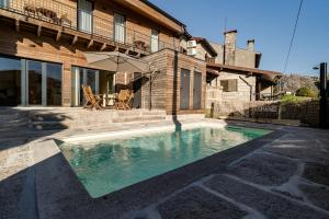a swimming pool in front of a house at Casa Da Avó Custódia in Campo do Gerês