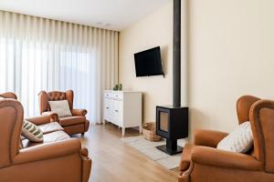 a living room with two chairs and a fireplace at Casa Da Avó Custódia in Campo do Gerês