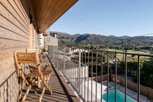 a balcony with a chair and a swimming pool at Casa Da Avó Custódia in Campo do Gerês