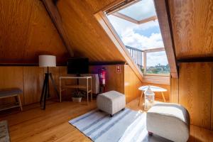 a attic room with a skylight and a living room with a window at Casa Afonso - Passadiços do Paço in Aveiro