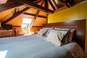 a bedroom with a large bed with a wooden headboard at Casa Afonso - Passadiços do Paço in Aveiro +54 photos