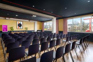 an empty lecture hall with chairs and a stage at Moxy Paris La Villette in Paris