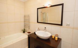 a bathroom with a sink and a tub and a mirror at Refugio do Couto in Cabeceiras de Basto +37 photos
