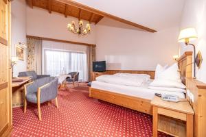 a hotel room with a bed and a desk at Hotel Edenlehen in Mayrhofen +123 photos