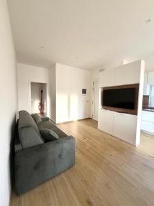 a living room with a couch and a flat screen tv at Velù Apartment in Porto Viro
