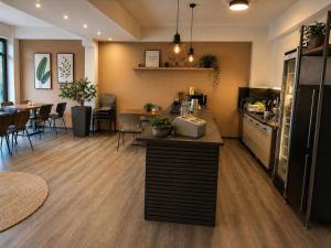 a restaurant with a kitchen with a counter and a dining room at Pension Sara in Magdeburg