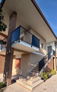 a building with stairs and a balcony on it at Velù Apartment in Porto Viro