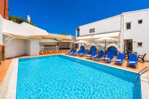 a pool with chairs and umbrellas next to a building at Kavos Panorama Hotel in Kavos