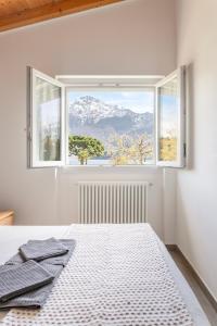 a white bedroom with a bed and a window at Camping Italia 90 Apartments in Domaso +31 photos