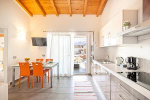 a kitchen with orange chairs and a table in a room at Camping Italia 90 Apartments in Domaso