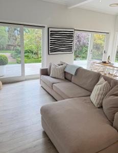 a living room with a couch and some windows at Woodlands - Vineyard setting in Penwortham
